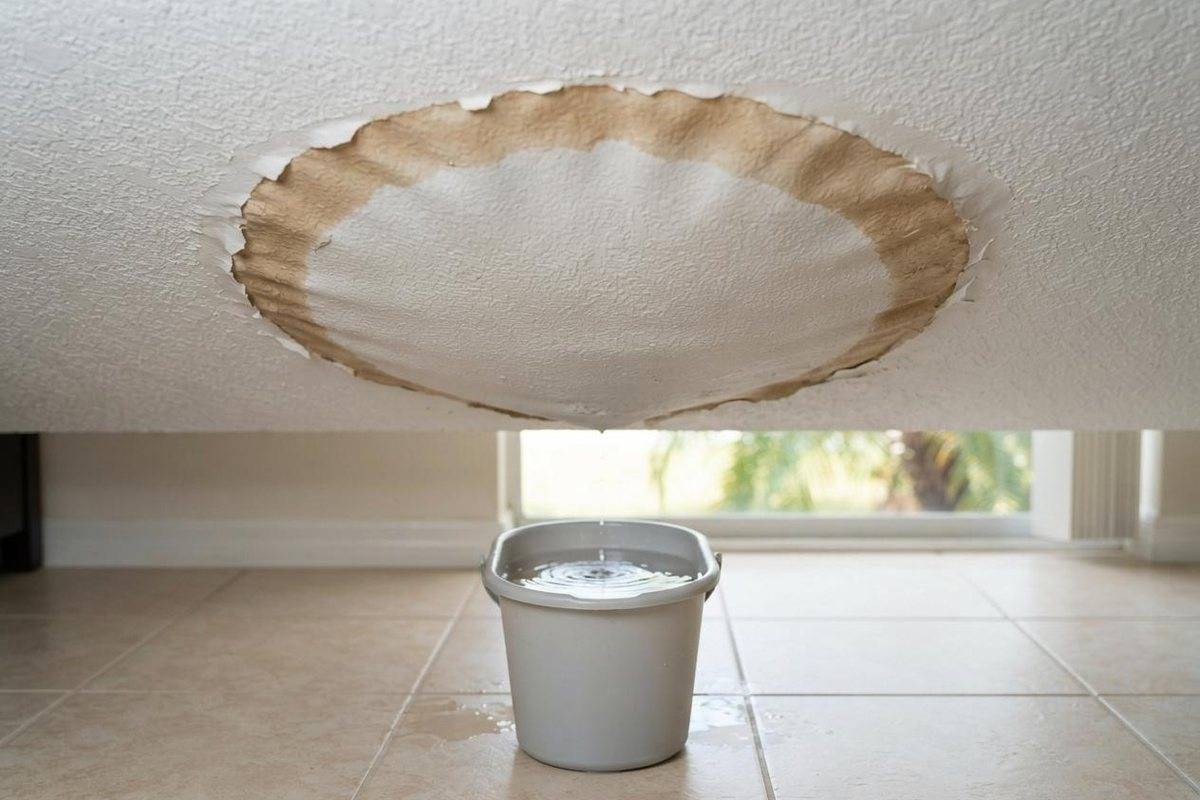 Water-stained, sagging ceiling dripping into a bucket
